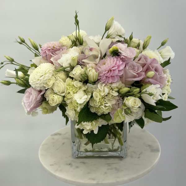 Pink and white mixed bouquet in a clear square vase