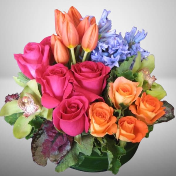 Mixed bouquet of pink roses, orange tulips, and blue flowers