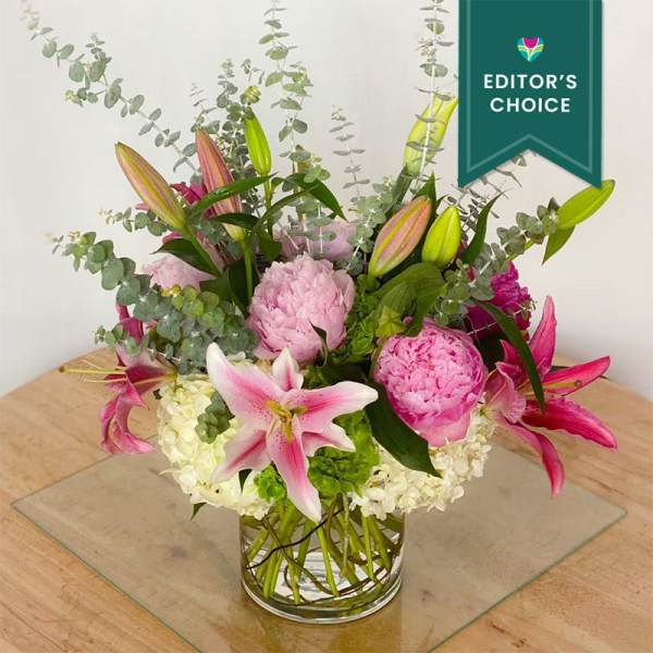 Pink lilies and peonies in a clear glass vase