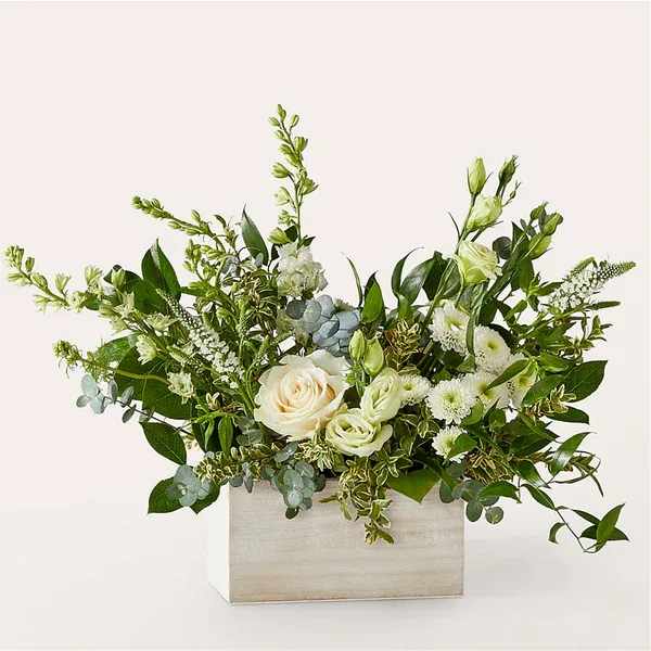 White roses and green blooms in a rectangular wooden box