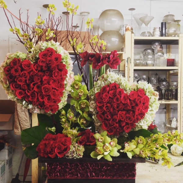 Heart-shaped red rose arrangements with orchids in a decorative box