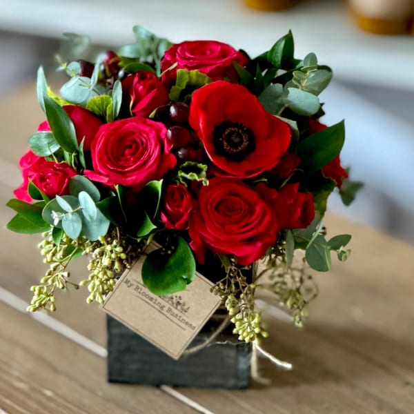 Red rose bouquet with a red anemone in a black box