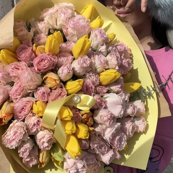 Pink and yellow bouquet wrapped in yellow paper