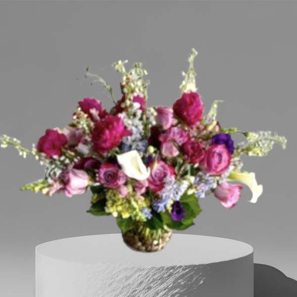 Mixed bouquet of pink, white, and purple flowers in a woven vase