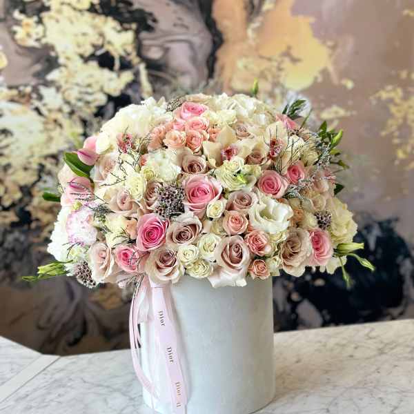 Round bouquet of pink and white roses in a white hat box