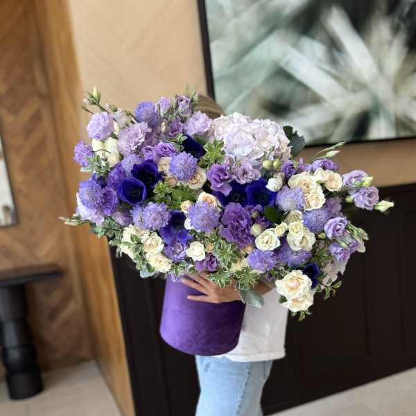 Large bouquet of purple and white flowers in a purple wrap