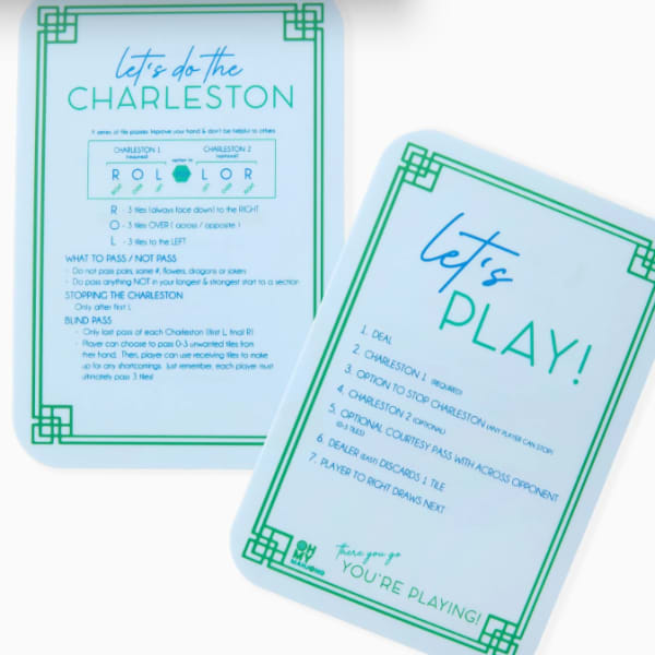 Two printed game instruction cards with blue and green text