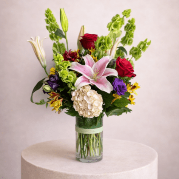 Mixed bouquet with lilies, roses, and hydrangea in a glass vase