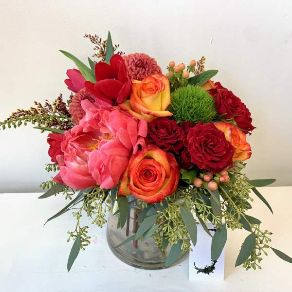 Red and pink floral arrangement in a glass vase