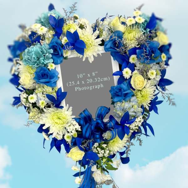 Heart-shaped floral wreath with blue and white flowers and ribbon