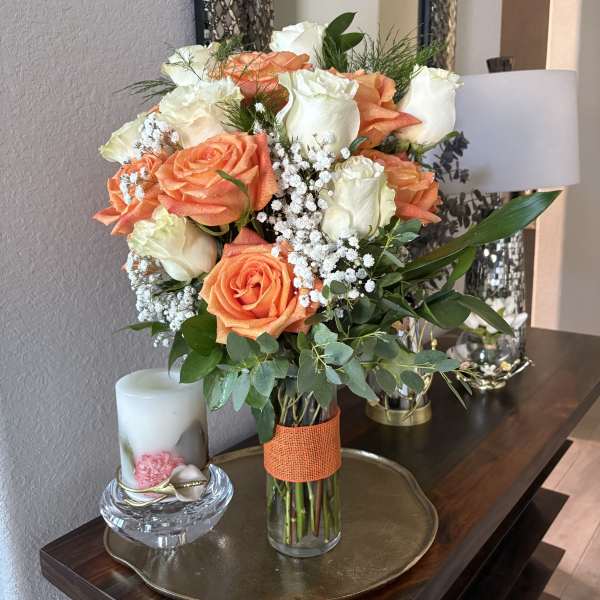Bouquet of peach and white roses in a glass vase