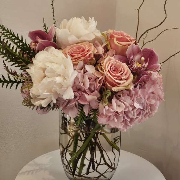 Pink and white floral arrangement in a clear glass vase