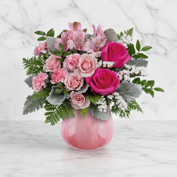 Pink roses and alstroemeria in a pink glass vase