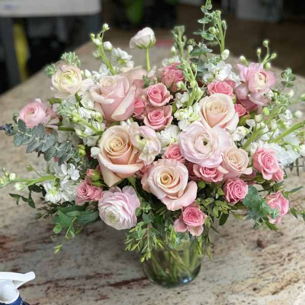Pink and white rose bouquet in a glass vase