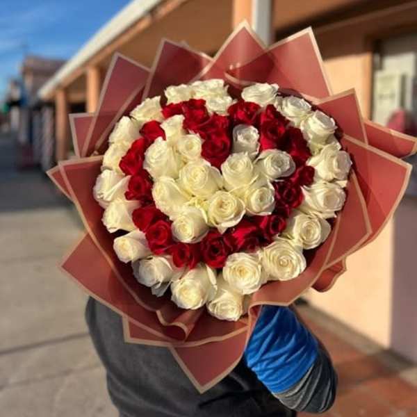 Bouquet of red and white roses wrapped in pink paper