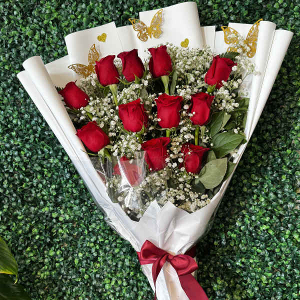 Bouquet of red roses with baby's breath in white wrap and a red ribbon