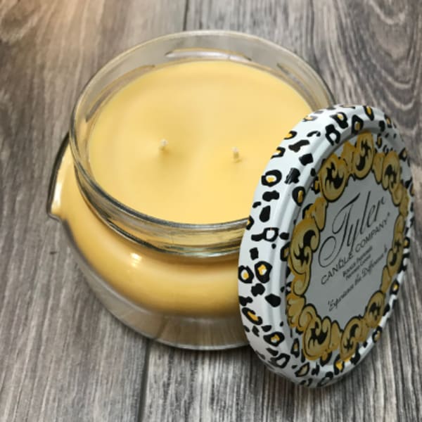 Yellow candle in a glass jar with a patterned lid
