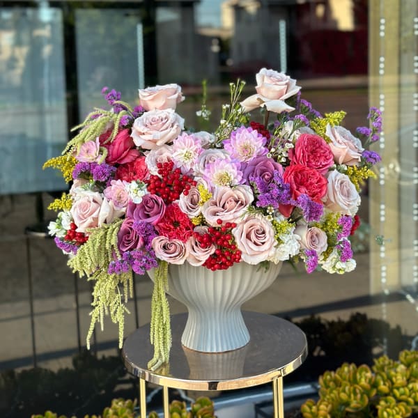 Large mixed bouquet of pink and purple roses in a white vase