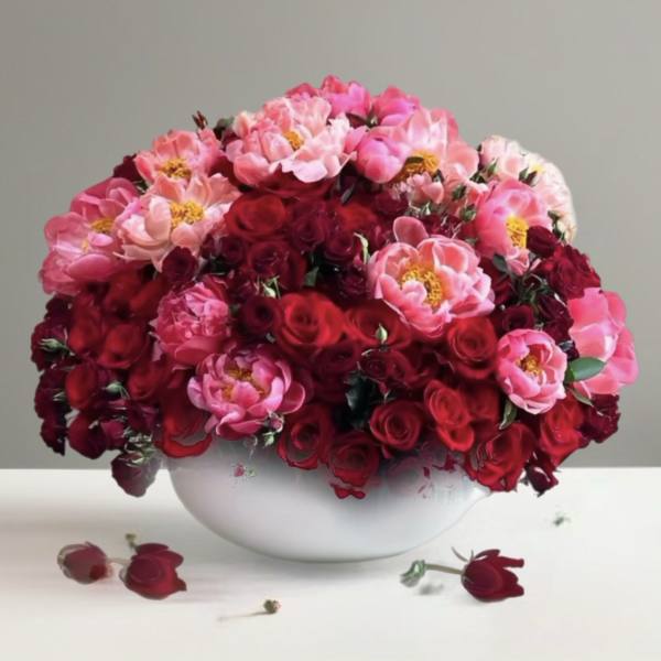 Red and pink roses in a white bowl vase
