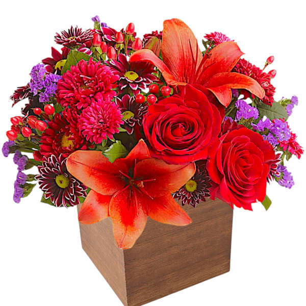 Red and orange floral arrangement in a wooden cube vase