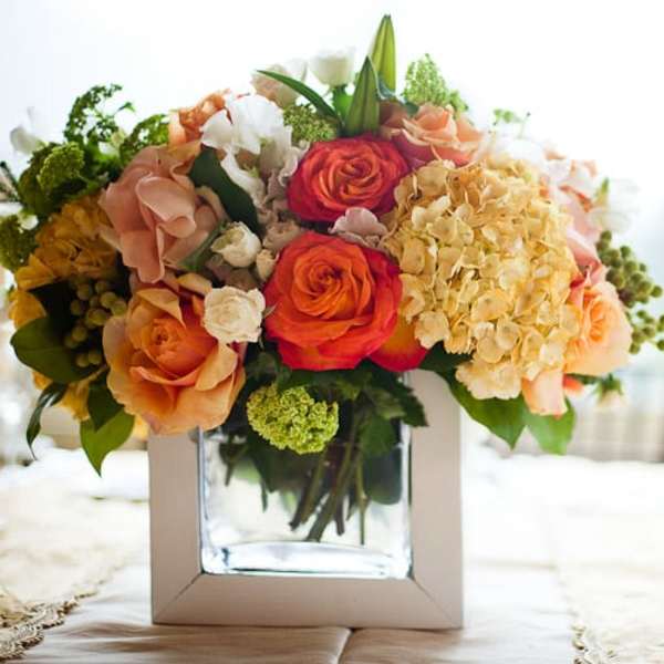 Mixed bouquet of roses and hydrangeas in a square glass vase