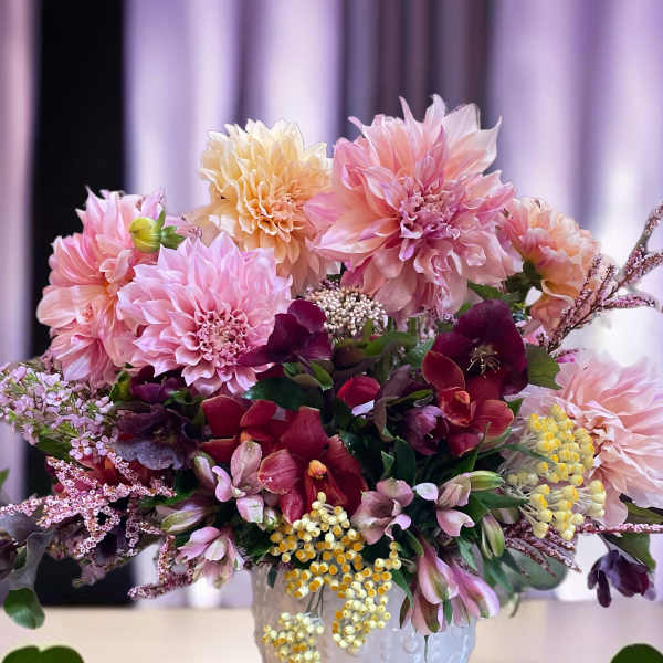 Pink and peach floral arrangement in a white textured vase