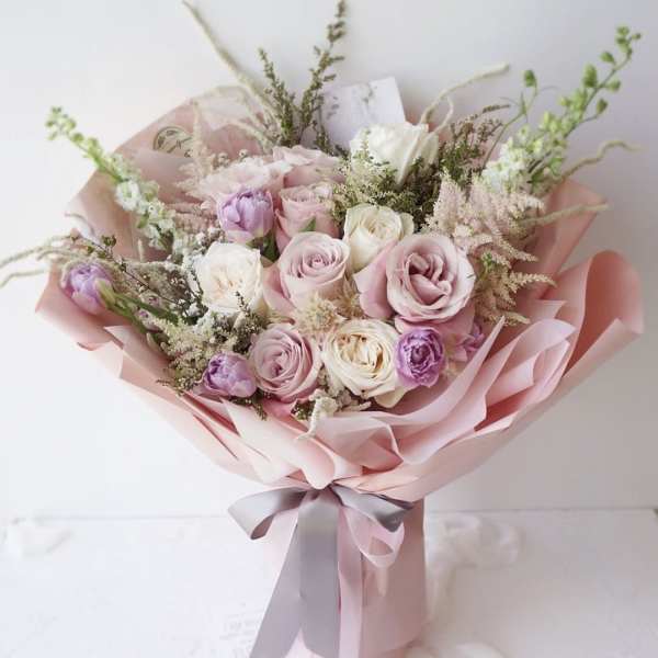 Pink and white rose bouquet wrapped in pale pink paper