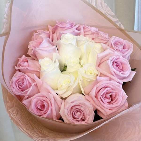 Bouquet of pink and white roses wrapped in pink paper