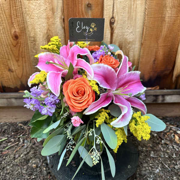 Bouquet of pink lilies and orange roses with purple flowers