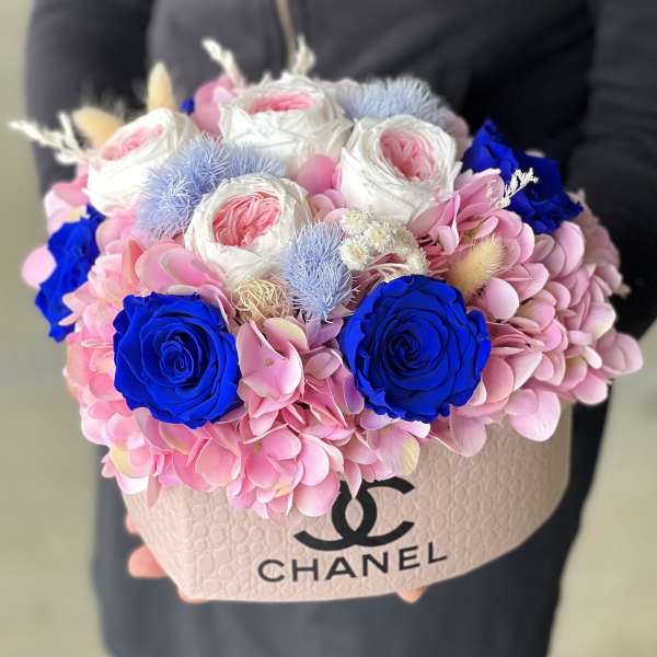 Pink and blue floral arrangement in a Chanel box