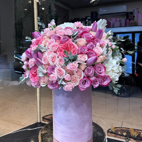Large pink and lavender rose arrangement in a tall purple box