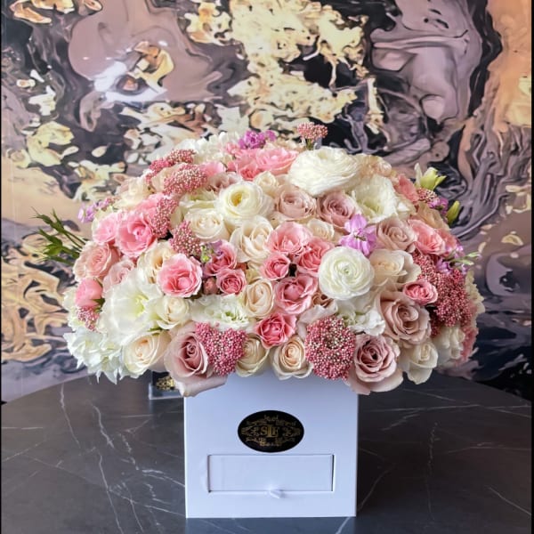 Large pastel bouquet of pink and white roses in a white box
