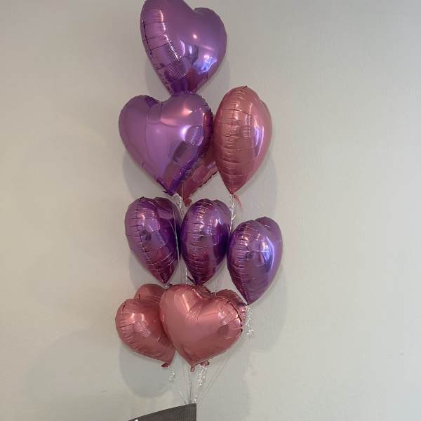 Pink rose bouquet with heart-shaped balloons above it