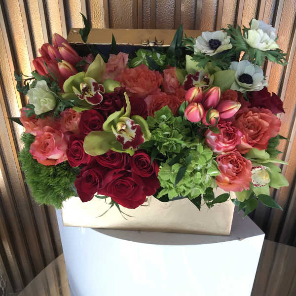 Mixed bouquet in a gold box with red, pink, and white blooms