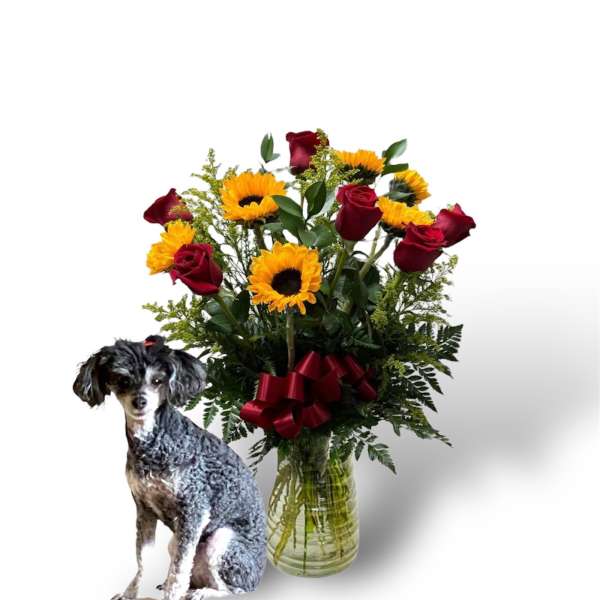 Bouquet of red roses and yellow sunflowers in a glass vase with a dog cutout