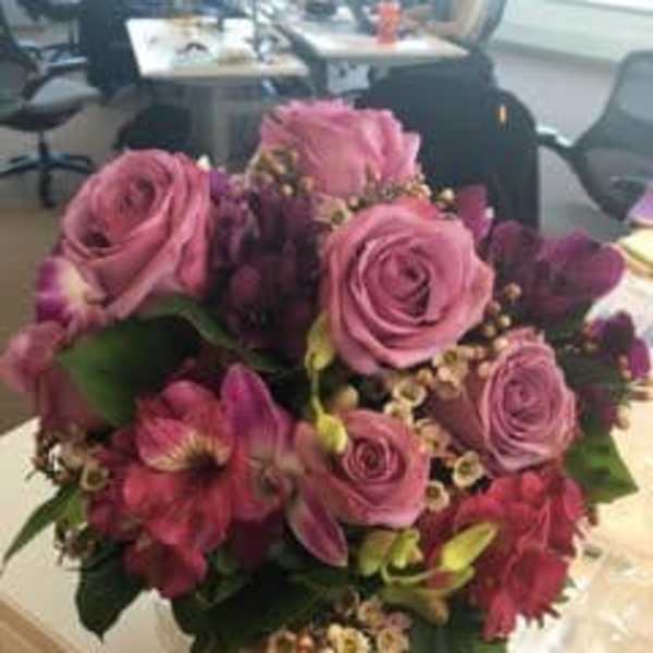 Pink roses and magenta flowers in a hand-tied bouquet