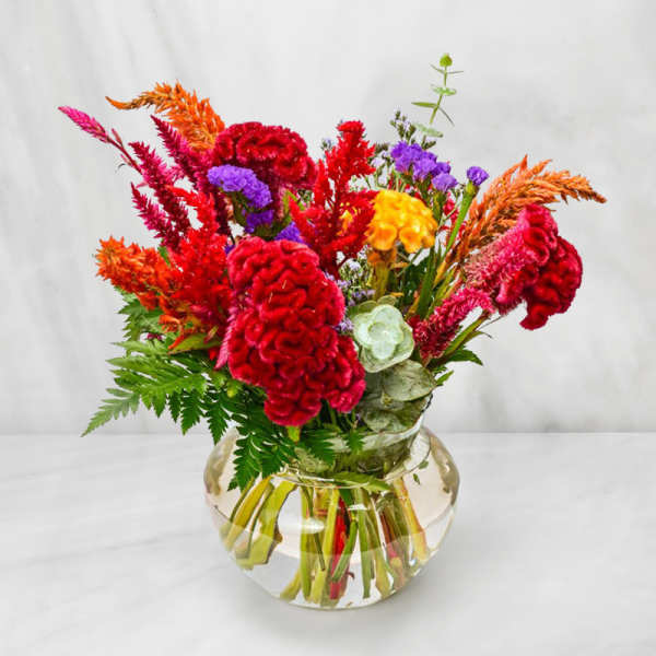 Bright mixed bouquet in a round glass vase