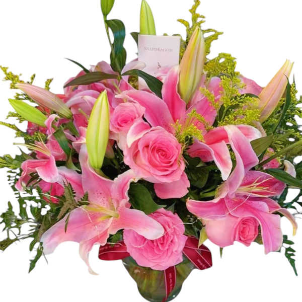 Pink lilies and roses arranged in a glass vase