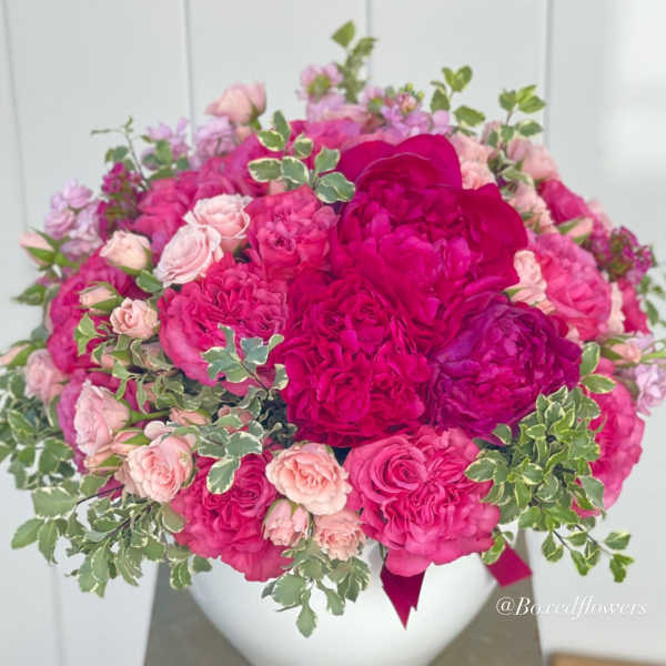 Pink and magenta rose bouquet in a white vase
