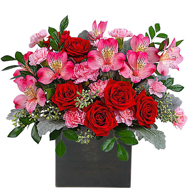 Red roses and pink flowers arranged in a black square vase