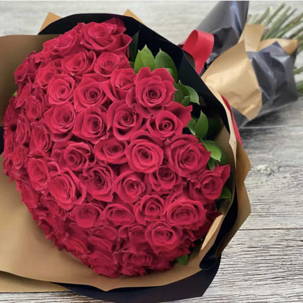 Large bouquet of hot pink roses wrapped in brown and black paper