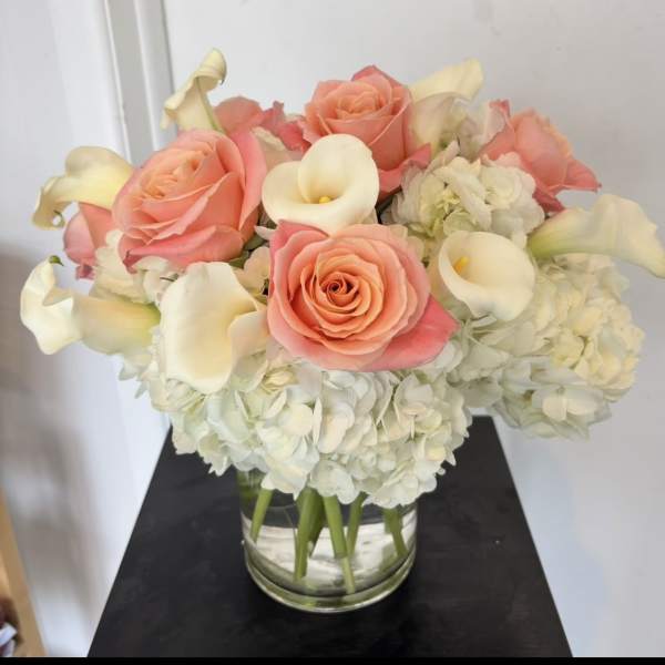 Pink roses and white calla lilies in a glass vase