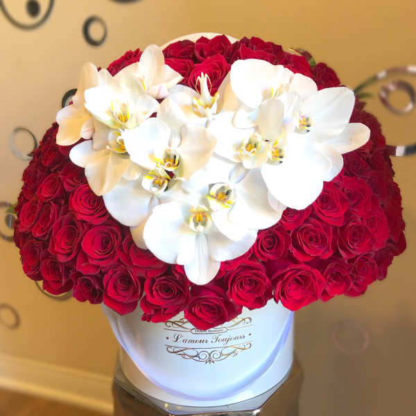 Red roses with white orchids in a white hat box