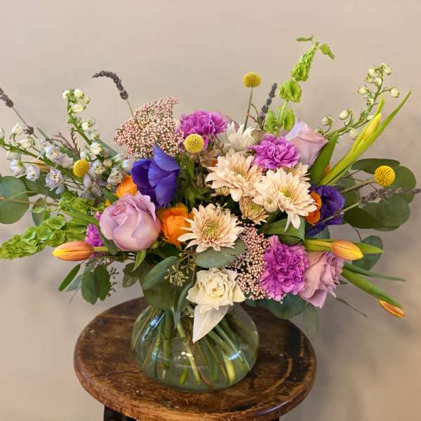 Mixed bouquet in a glass vase with purple, pink, white, and orange flowers