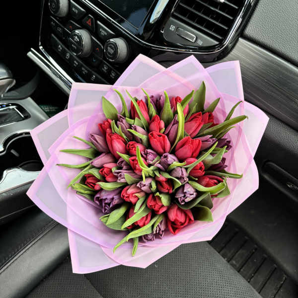 Bouquet of red and purple tulips wrapped in pink paper