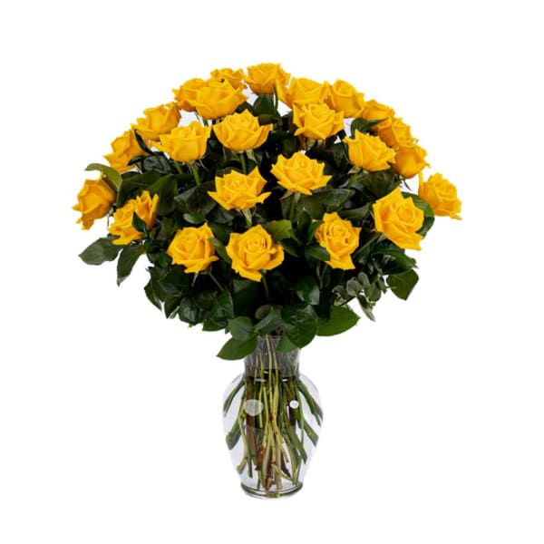 Tall arrangement of yellow roses in a clear glass vase