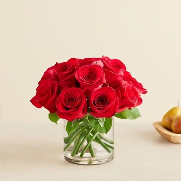 Red roses arranged in a clear glass vase