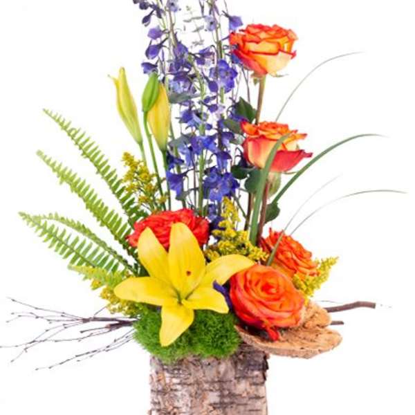 Tall mixed flower arrangement with orange roses, yellow lily, and purple blooms