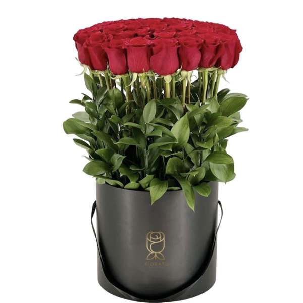 Round box of red roses with green foliage