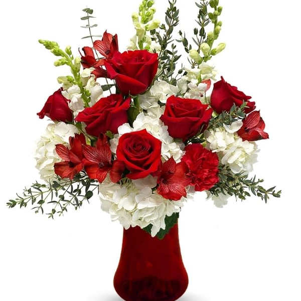 Red roses and white flowers arranged in a red vase